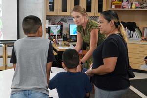 Teacher explains something to student and parent