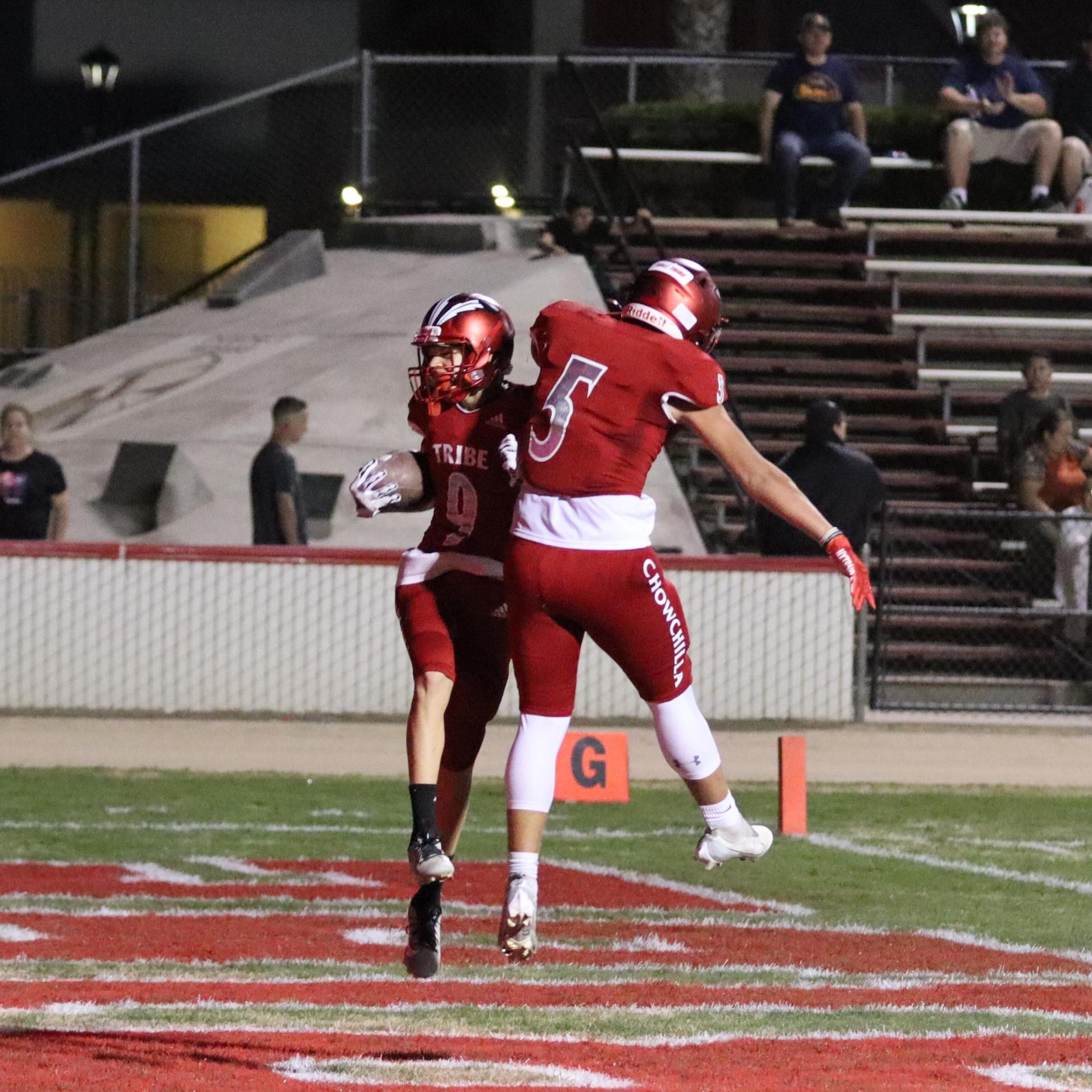varsity football players in action against Riverdale