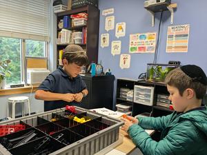 Two boys participate in a robotics challenge involving motors and gears