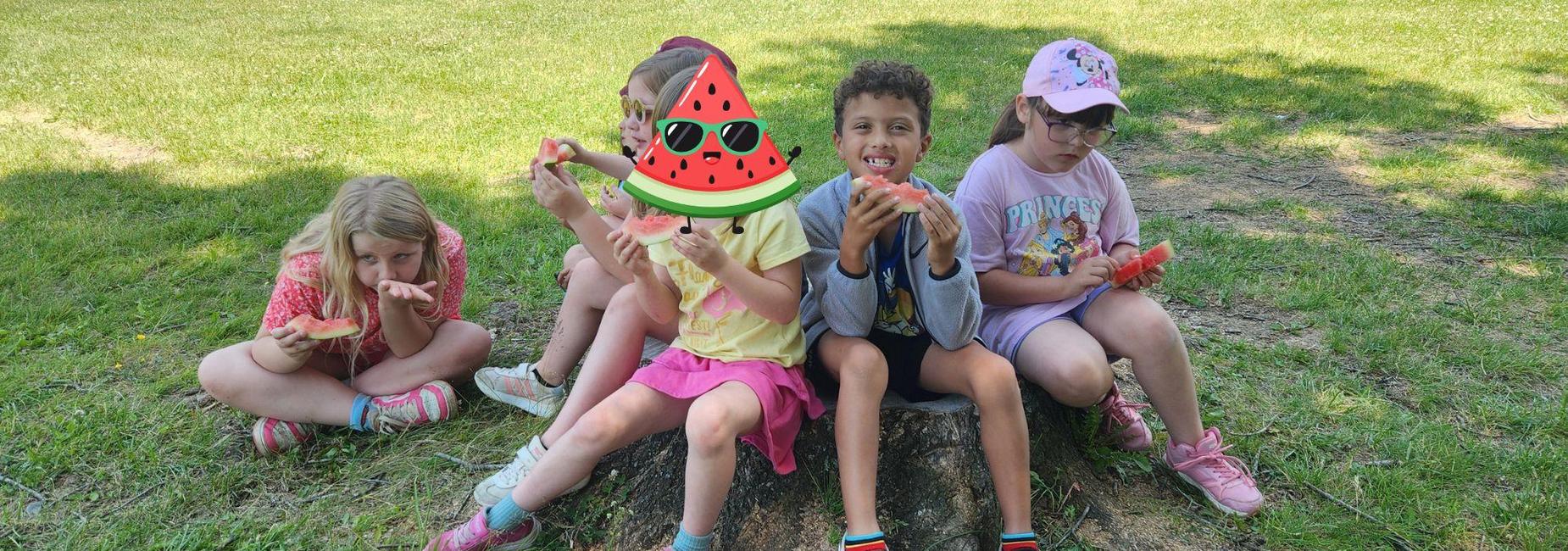 First graders enjoy watermelon outdoors