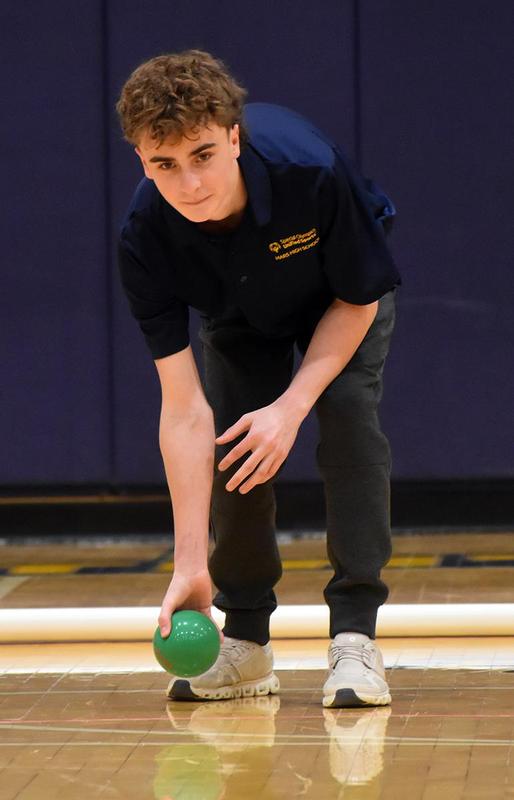 a boy rolling a bocce ball