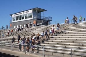 Teachers and students climb up and down the stairs in the stadium.