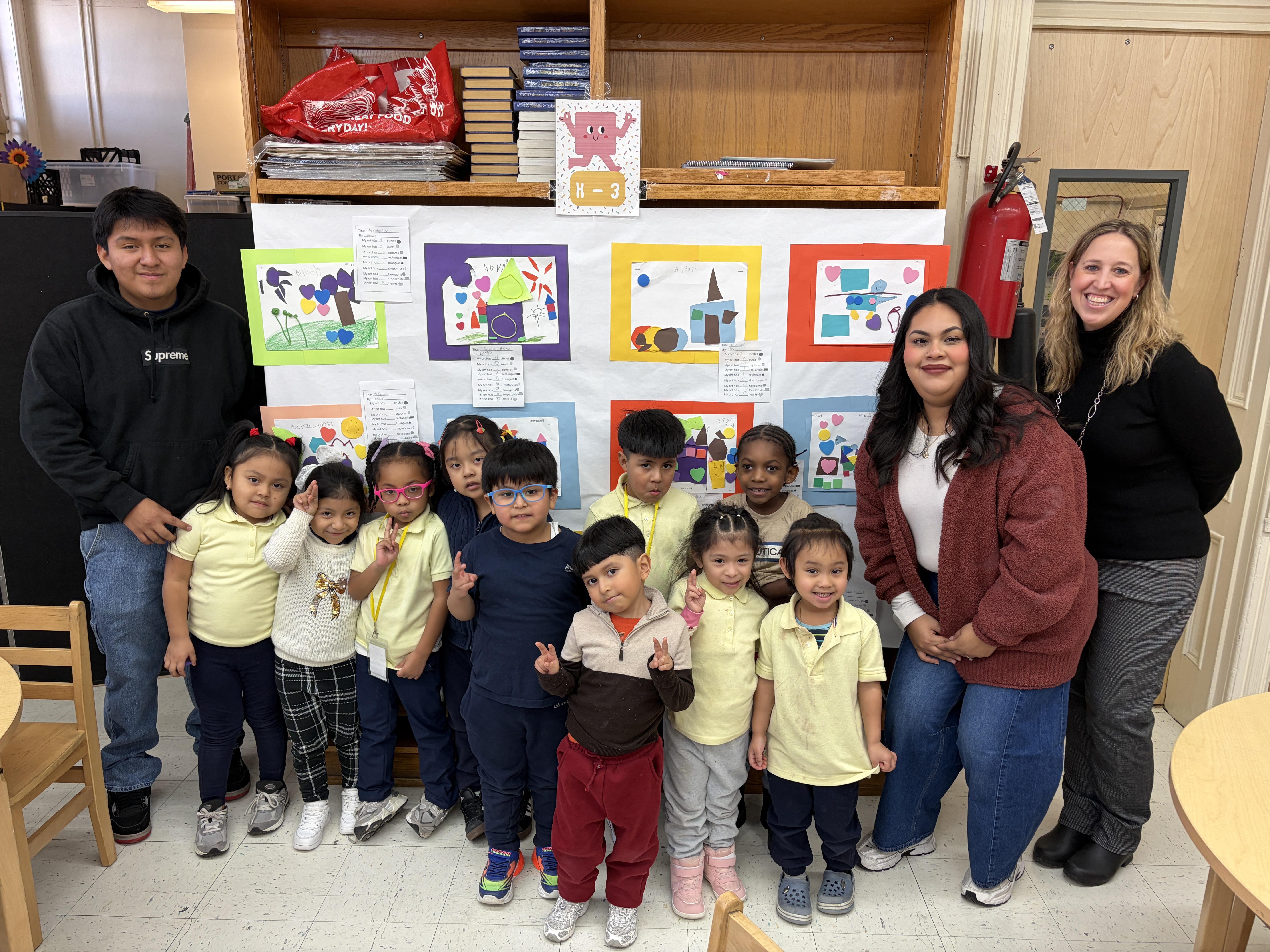 kindergarten class with teacher and parent during art show.