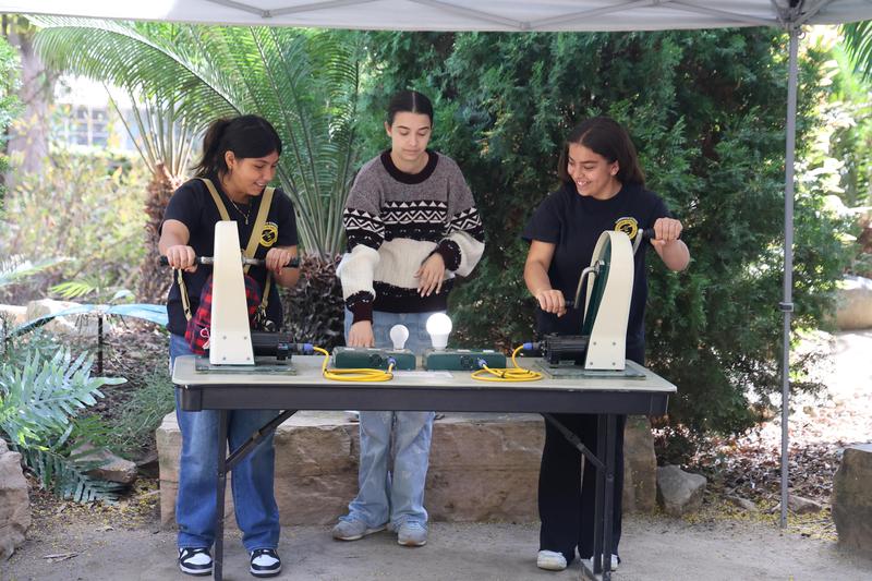 Students working on an experiment on how they can create energy to light up a lightbulb.