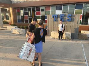 A family takes a first day of school photo