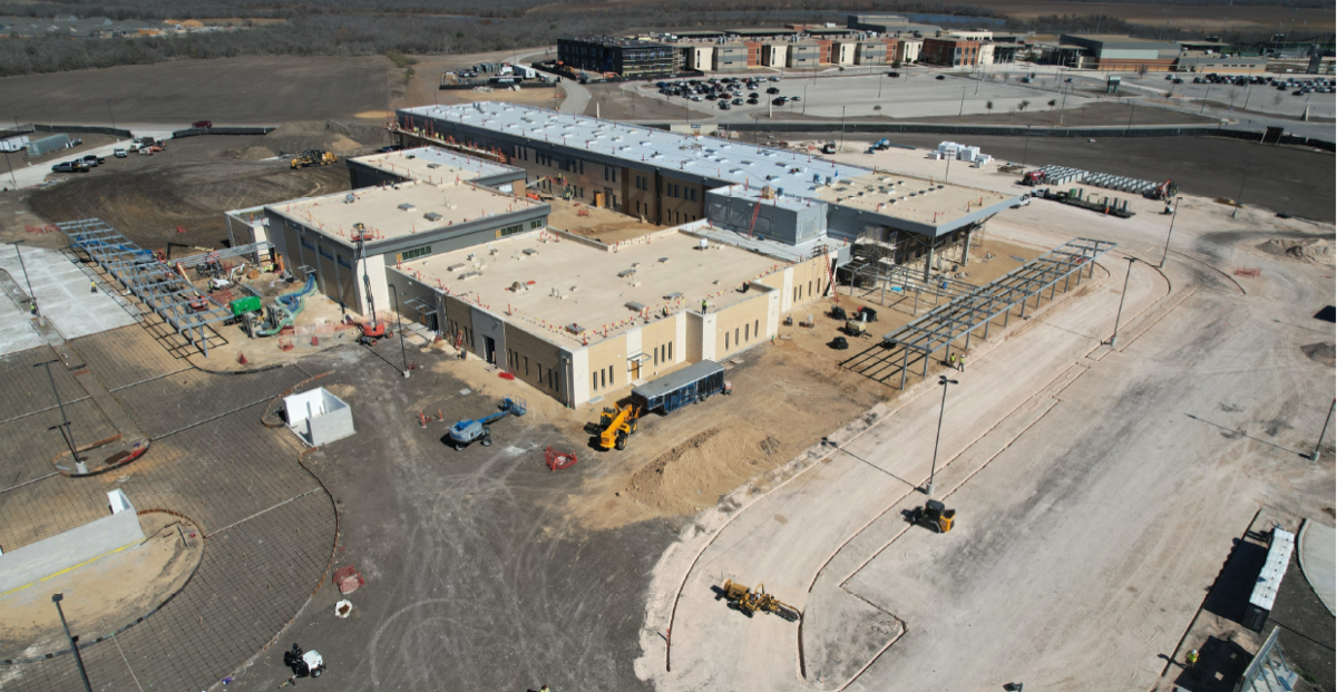 Aerial view of another school site with construction equipment and building progress.