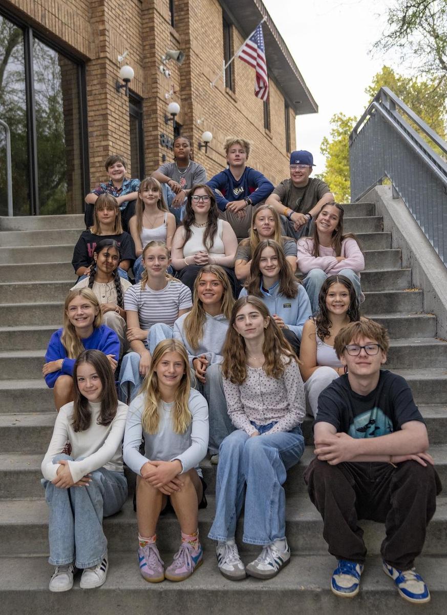 8th Grade Ambassadors sitting on steps outside school