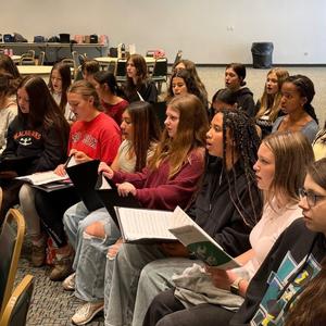 A group of students practicing the music with instructor.