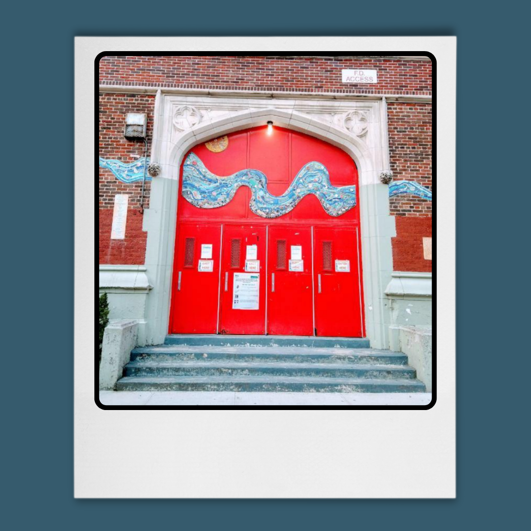 Brick school building with red doors. 