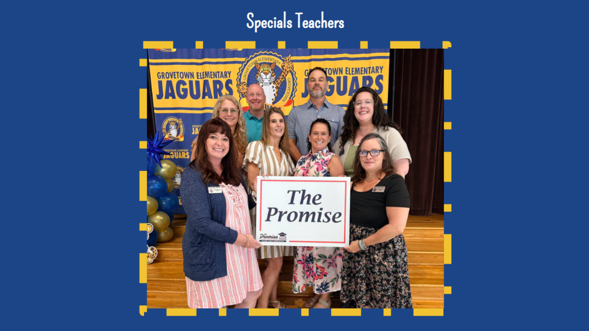 Group of teachers holding a sign that says 'The Promise' at an event.