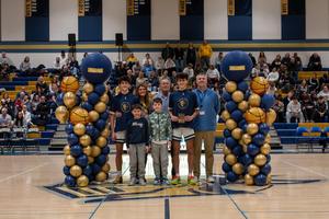 basketball player holding award surrounded by Shoop family