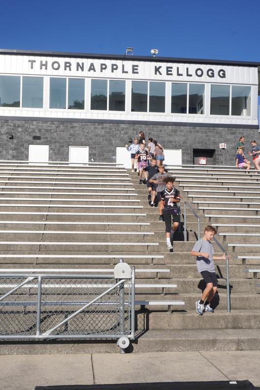 A line of students comes down the stairs in the stadium.