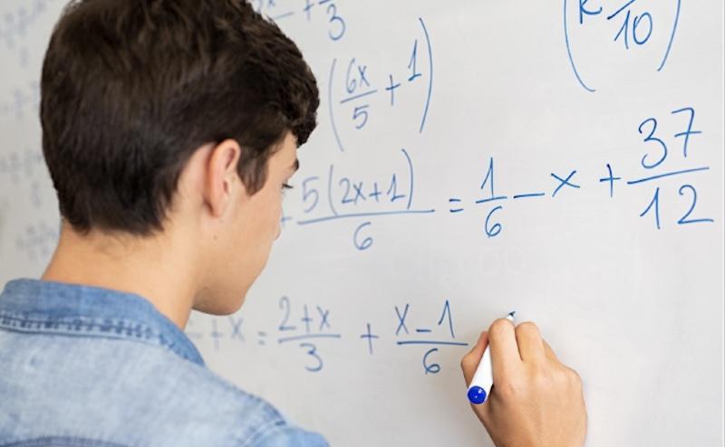 Student working on a math program at the whiteboard