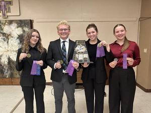 4 oral interpers holding a trophy and medals