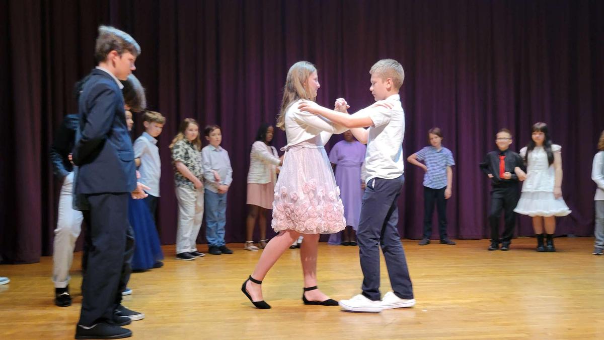 A group of children dancing on stage during a performance.