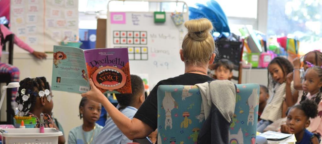 students listen to teacher reading a book