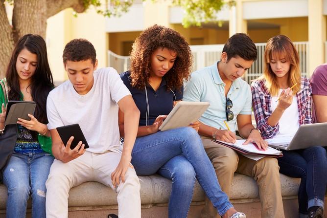 kids sitting on a wall reading or studying together