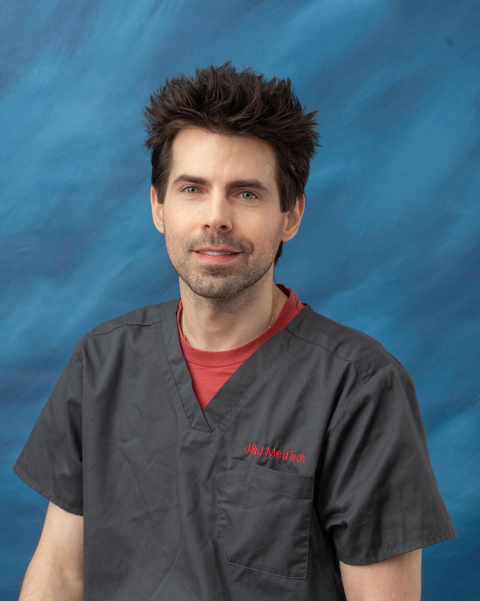  Photo of Mr. Donald Owens in a dark gray shirt sitting in front of a blue background.