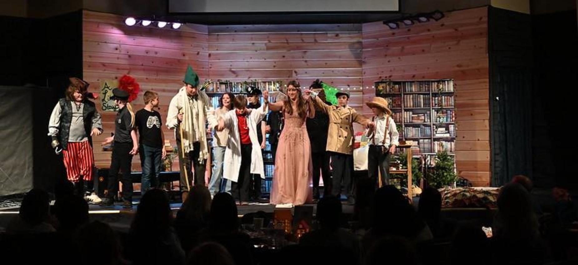 A group of actors performing on stage in a dramatic production.