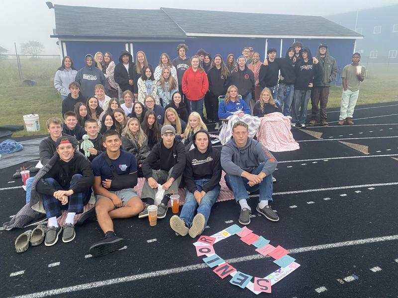Members of the Class of 2026 gather on the track to watch the sunrise