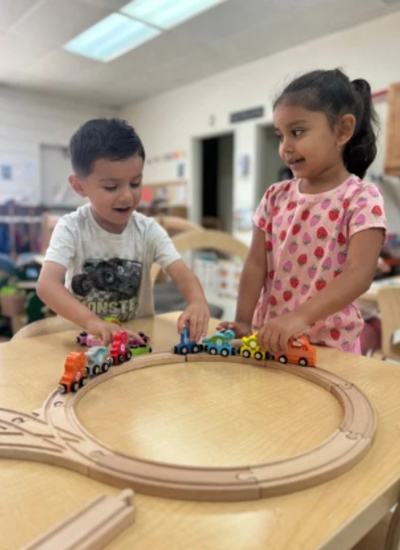 Two students playing with a train