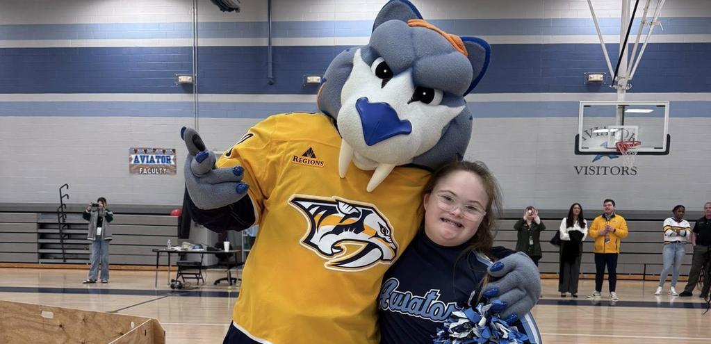 Nashville Predators Mascot, GNASH, standing with young cheerleader