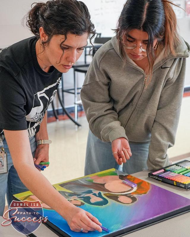 - Memorial Early College High School art teacher Ashley Buehler assisting a student with their painting.