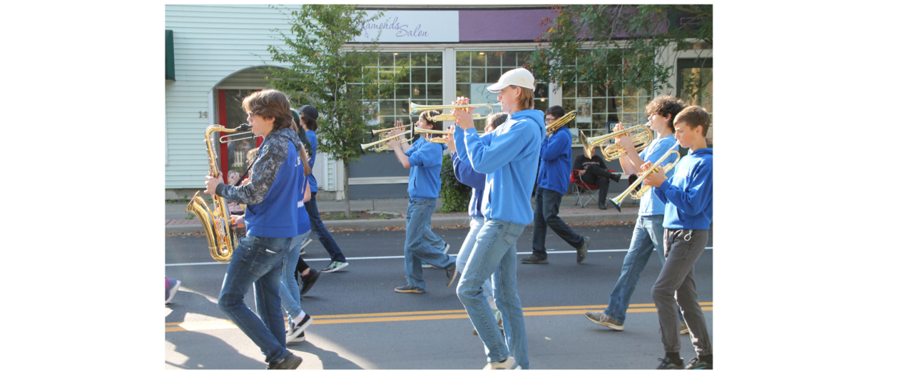 students marching playing trumpets and saxaphones