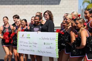 carissa jones fletcher with a giant check and cheer team