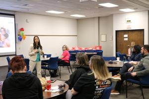 participants sit at round tables and listen to the keynote speaker talk