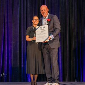 Tara Brown poses on stage with an award.