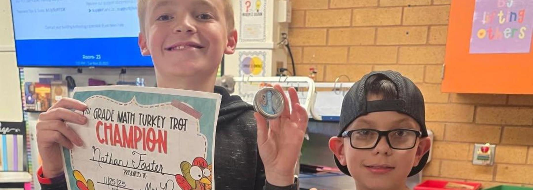 Two children holding awards for a turkey-themed contest in a colorful classroom.