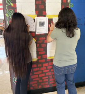 2 students work in the hall to comprehend a paragraph written in Spanish.