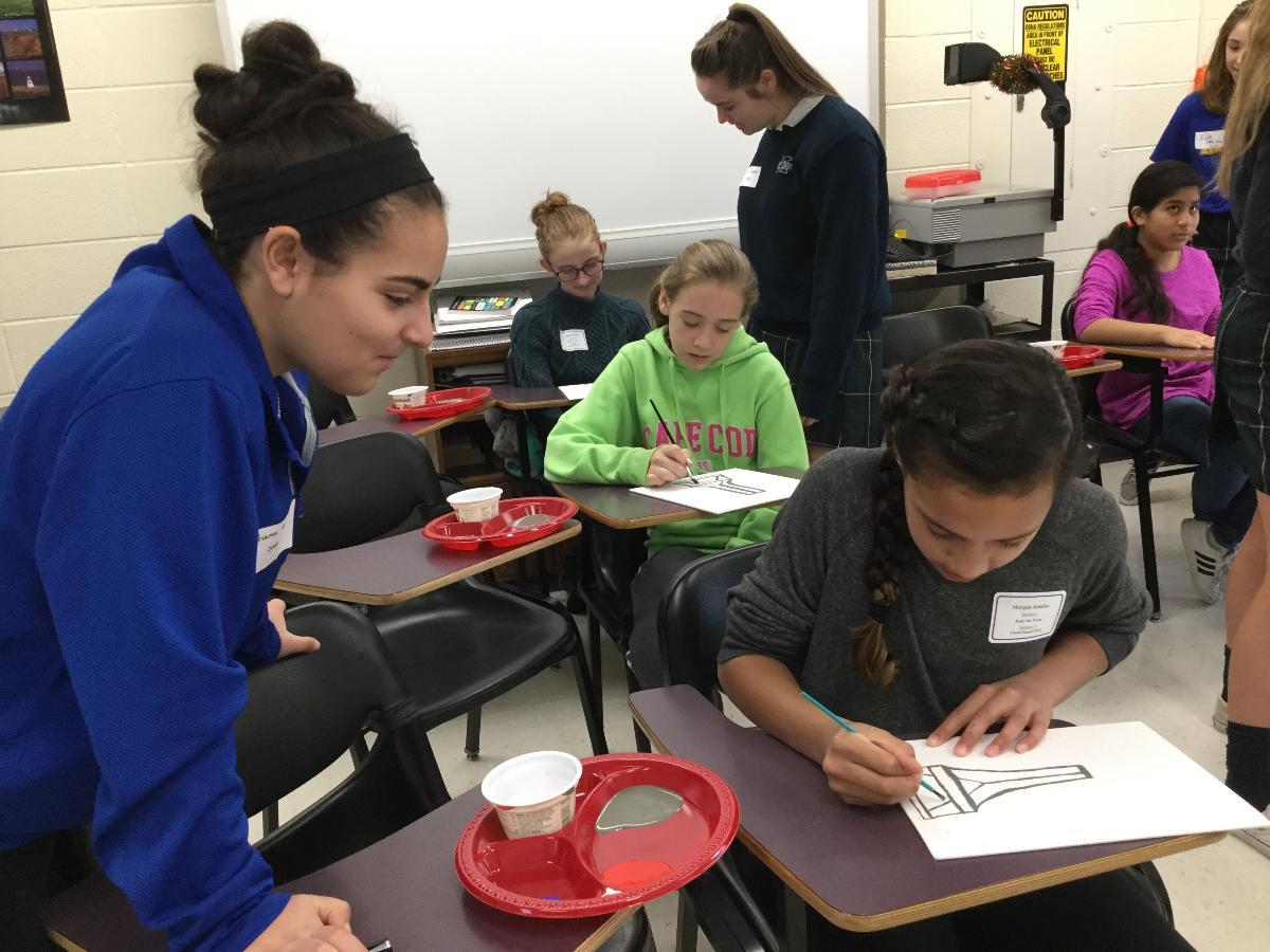 Students engaged in an art class, drawing at their desks.