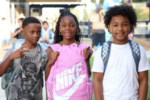 three students with backpacks on the first day of school