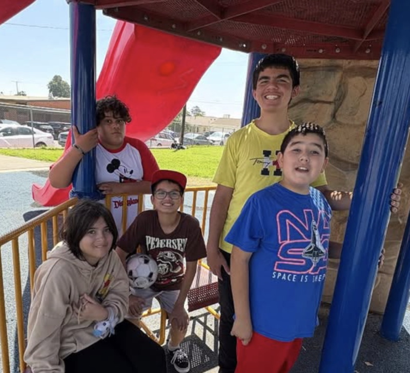 five students at playground equipment during recess