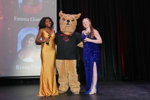 2 seniors and the BHS mascot on stage with Oscar trophies