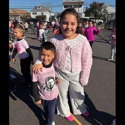 Students smiling outside in school parking lot.