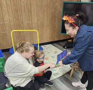 parent, student, and staff member reading a book