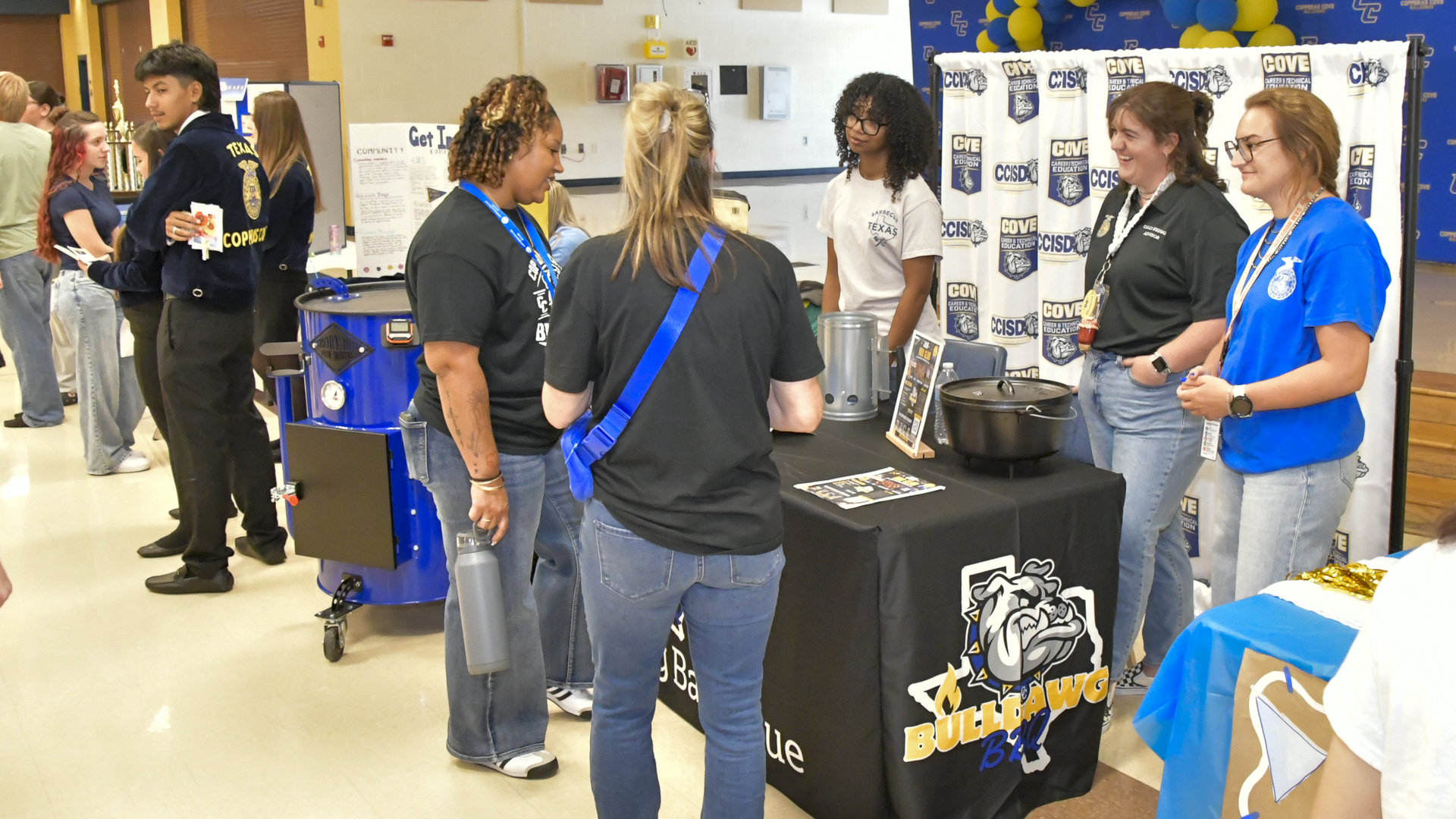 Group of students at a table promoting an event in a school setting.