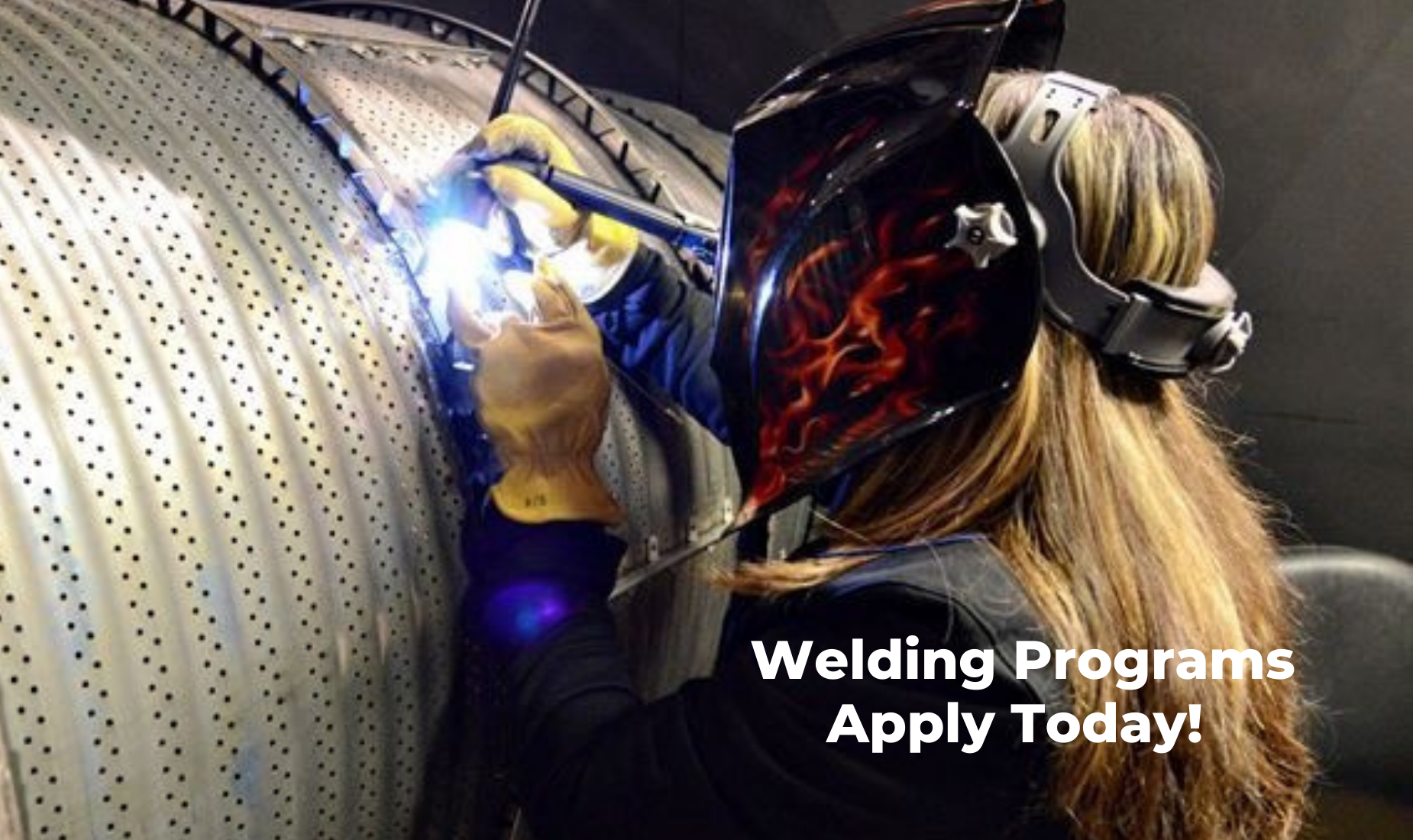 Person welding with a helmet, promoting welding programs.