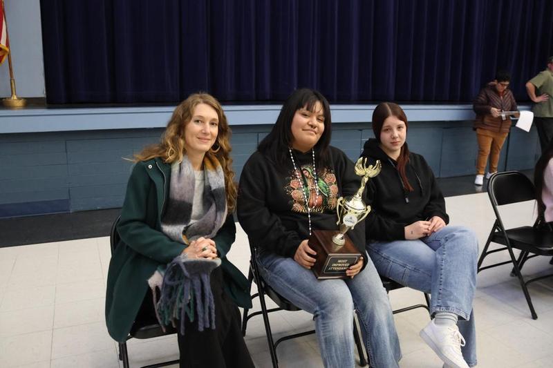 Students holding most improved trophy