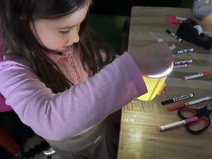 A kindergarten student works on her star projector
