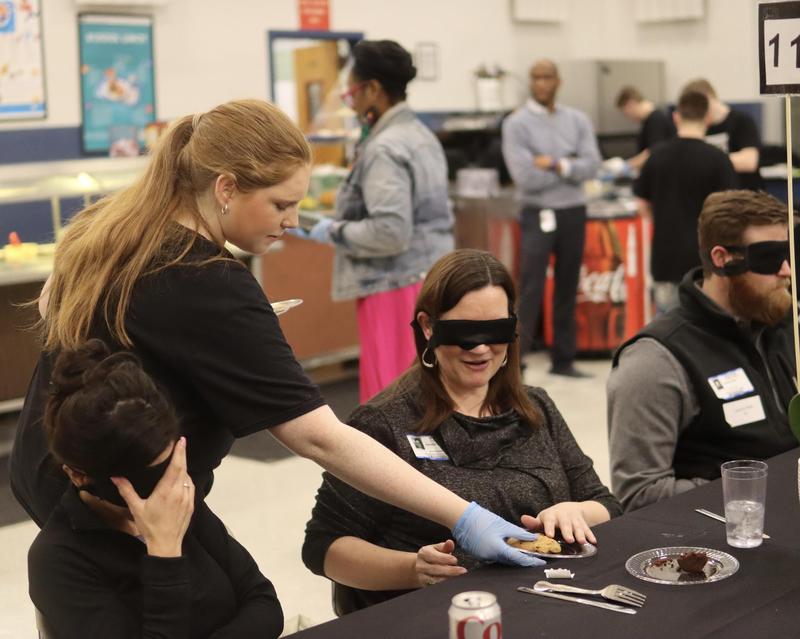 Blindfolded guests are served by a student during Lights Out Dining.