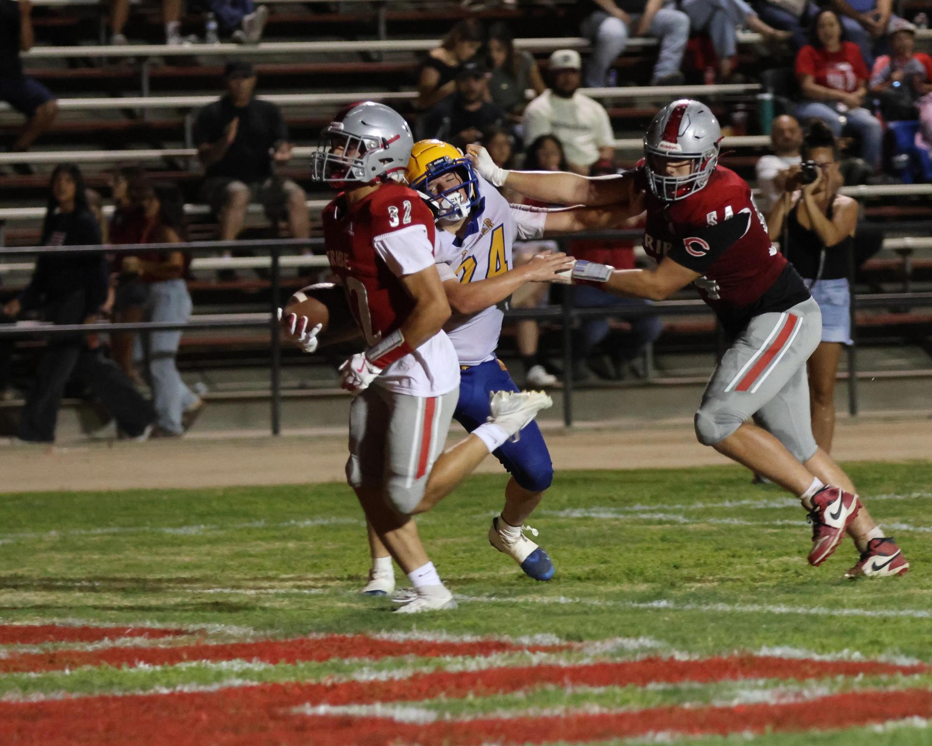 Varsity football players in action against Parlier 90