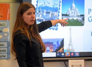 Student discussing European landmarks with a presentation on the screen.