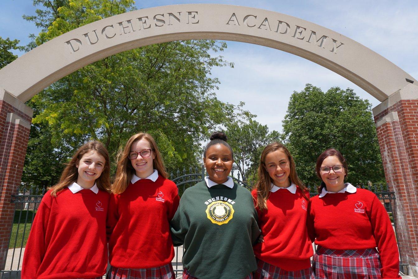 Students in front of Duchesne Academy sign