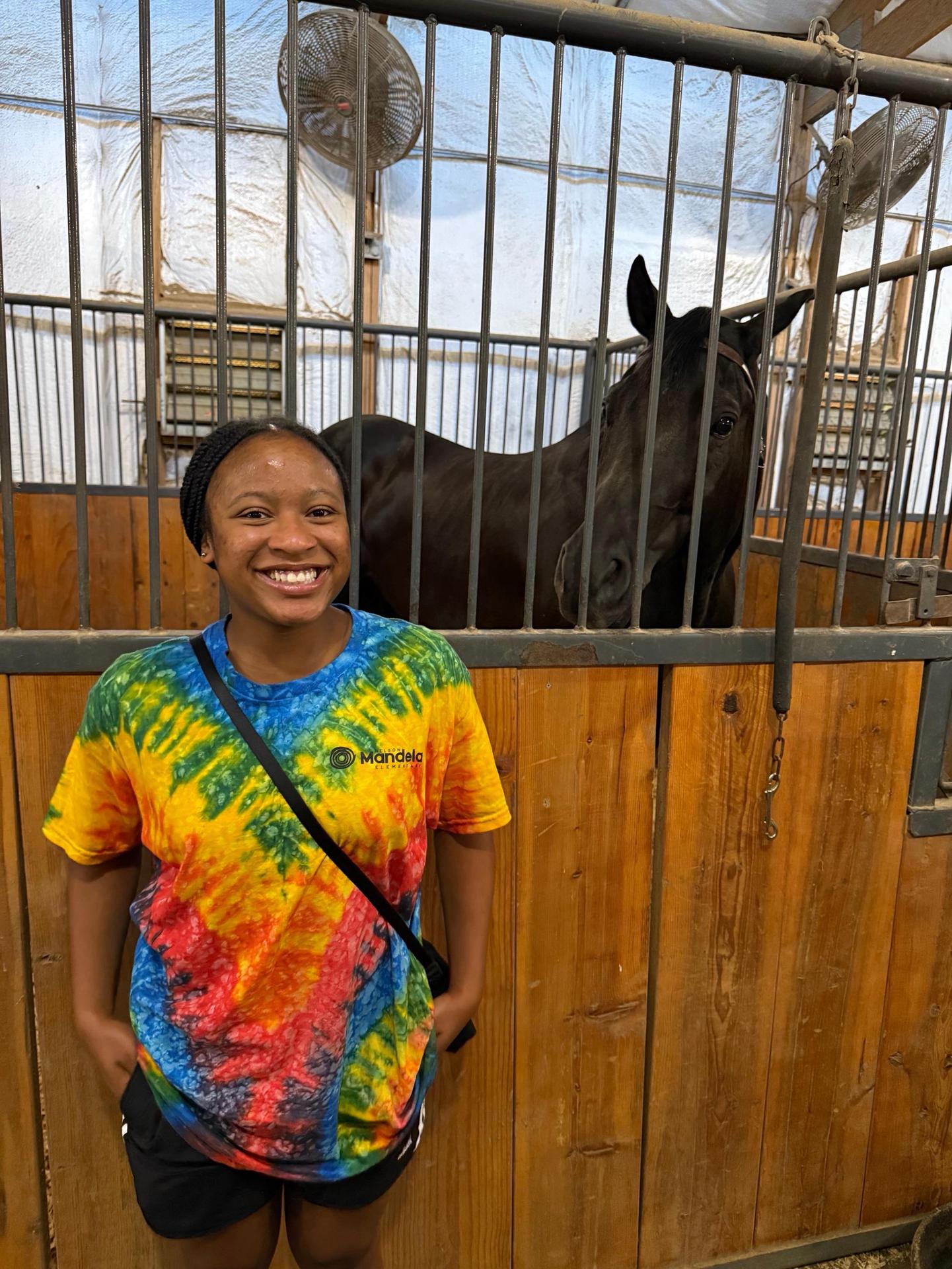  Standing in front of a horse in a stable.