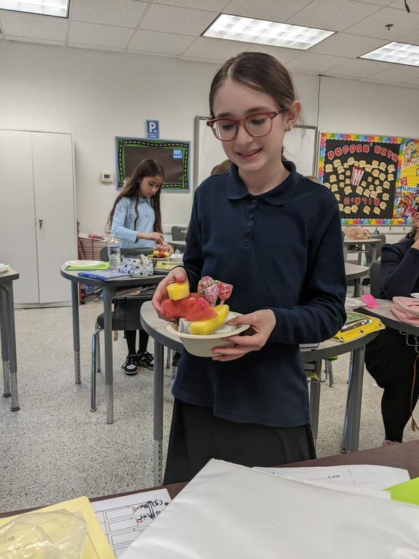 a girl shows off her edible fruit arrangement