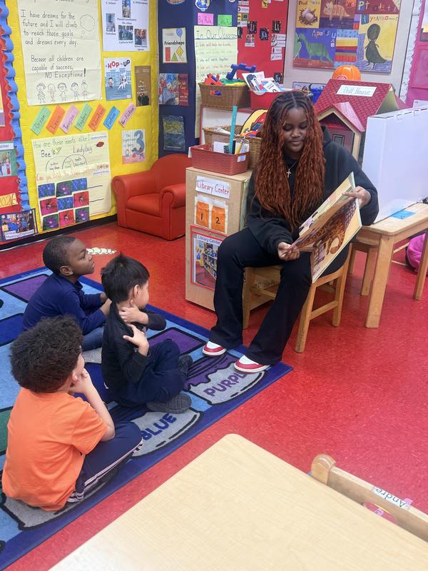 Student sitting in a chair and reading to students